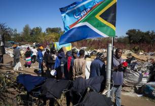 Os moradores locais esperam na fila durante uma distribuição de alimentos pela ONG Hennops River Revival em uma área de reciclagem de lixo no dia 61 do bloqueio nacional como resultado do Covid-19 Coronavirus, Pretória, África do Sul, 27 de maio de 2020.