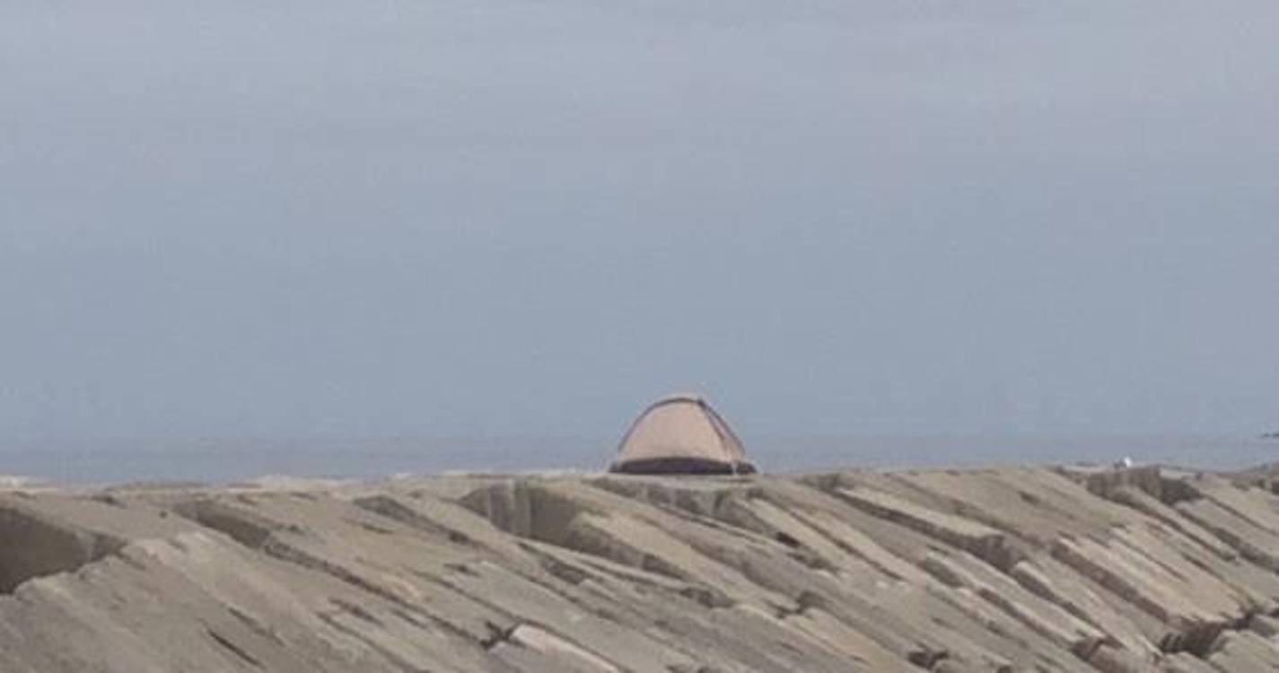 Turistas montam tenda nos quebramares da praia da Ribeira Brava
