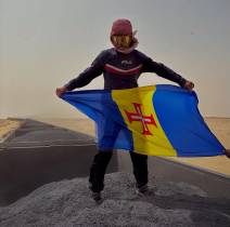 Em pleno deserto, num ‘comboio’ em andamento, o aventureiro exibe a bandeira da Madeira.