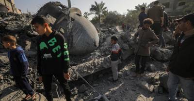 Palestinianos junto aos destroços da mesquita Al Bokhari atacada pelos israelitas.