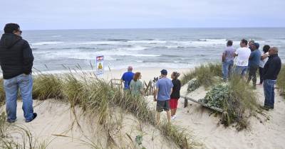 Populares observam os trabalhos de resgate da embarcação de pesca que virou ao largo das praias de São Pedro do Moel e de Vieira.