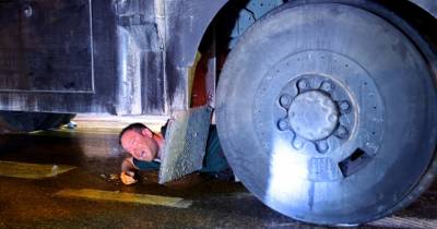 Manifestante deita-se debaixo de um autotanque para evitar o uso da viatura pela polícia.