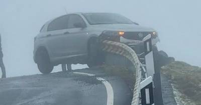 Carro ficou preso no rail de proteção.