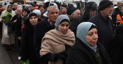 Palestinianos passam no chekpoint a caminho de Jerusalém, sob vigilância de Israel.