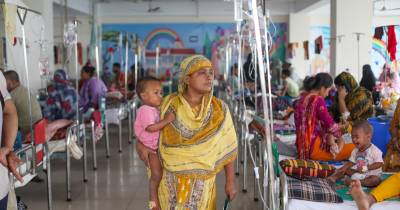 epa12935874 A woman caries a child as patients receive treatment after showing measles-like symptoms at Dhaka North City Hospital (DNCC) in Mohakhali, Dhaka, Bangladesh, 06 May 2026. According to the Directorate General of Health Services, 317 children have died from measles and measles-like symptoms in Bangladesh since mid-March 2026, as of 06 May. EPA/MONIRUL ALAM