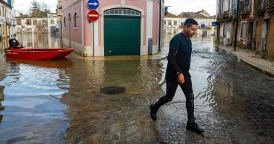 Um elemento da Proteção Civil caminha numa zona inundada da Ribeira de Santarém.