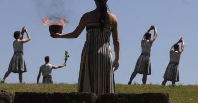 Junto às ruínas com 2.600 anos do templo a Hera, a ‘suma sacerdotisa’, interpretada pela atriz grega Mary Mina e vestida com um traje tradicional da Grécia Antiga, acendeu a pira.