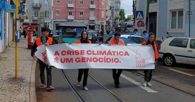 Os quatro jovens, em marcha lenta na rua, transportaram uma faixa com a frase “a crise climática é um genocídio”.