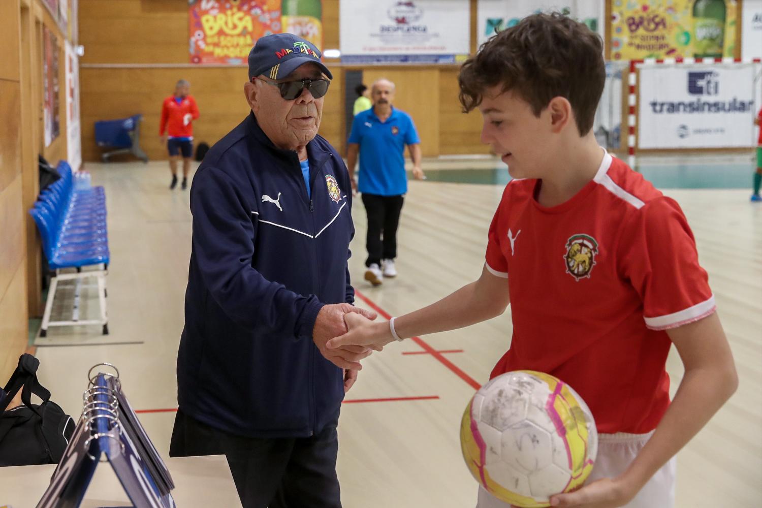 O massagista José Milagres, 95 anos, conversa com um jogador das camadas jovens, durante um jogo disputado no Pavilhão do CS Marítimo.
