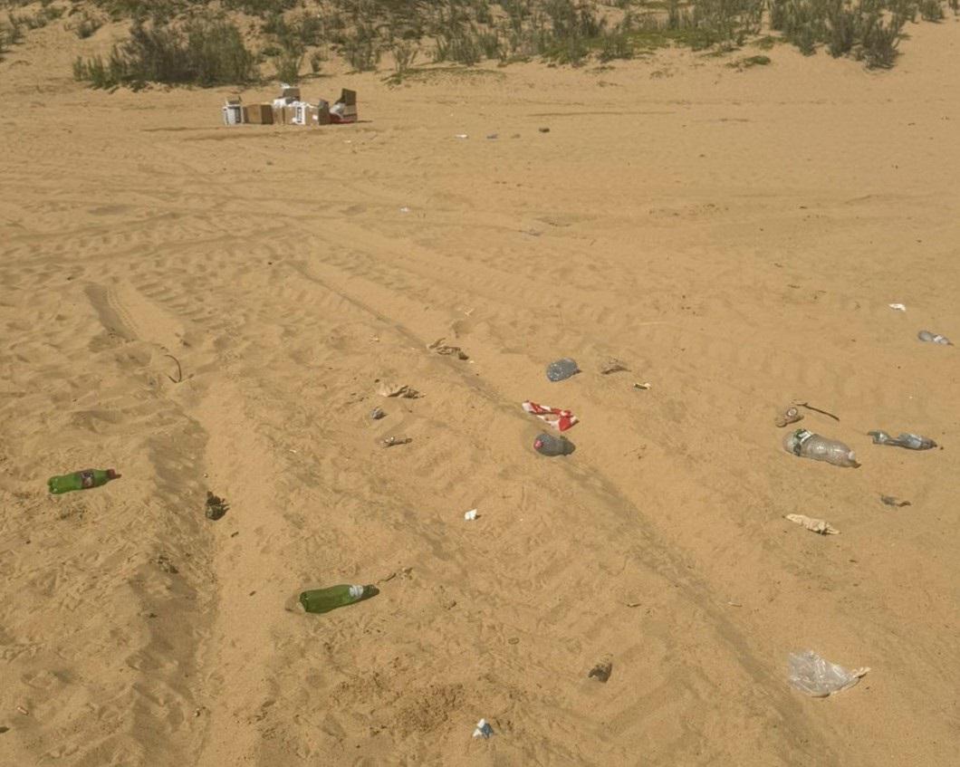 Nesta imagem é possível ver garrafas e caixas de cartão em plena praia.