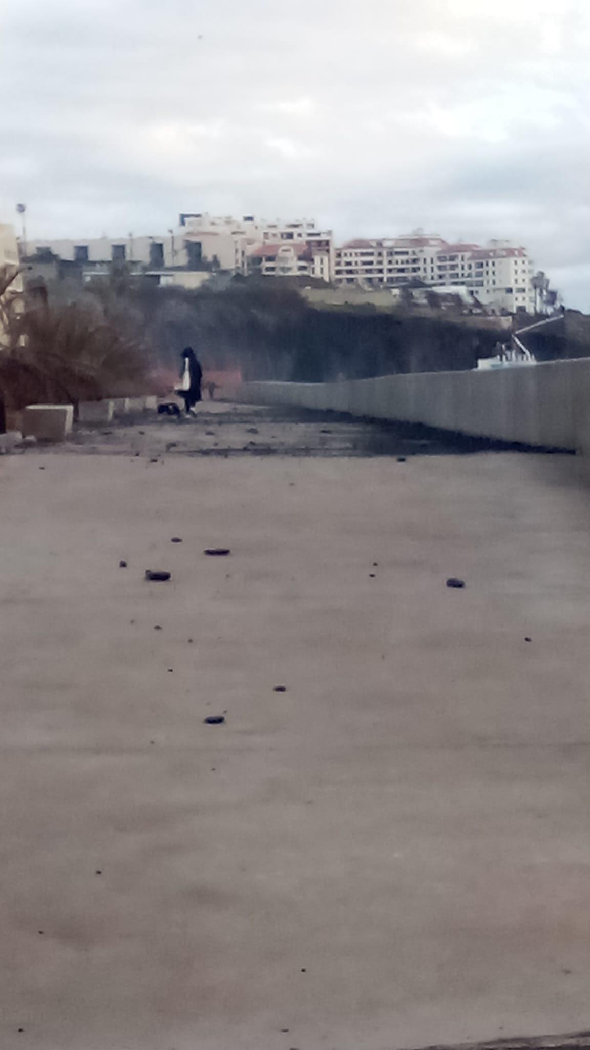 Apesar dos detritos arrastados pelo mar, as pessoas passam para outro lado.